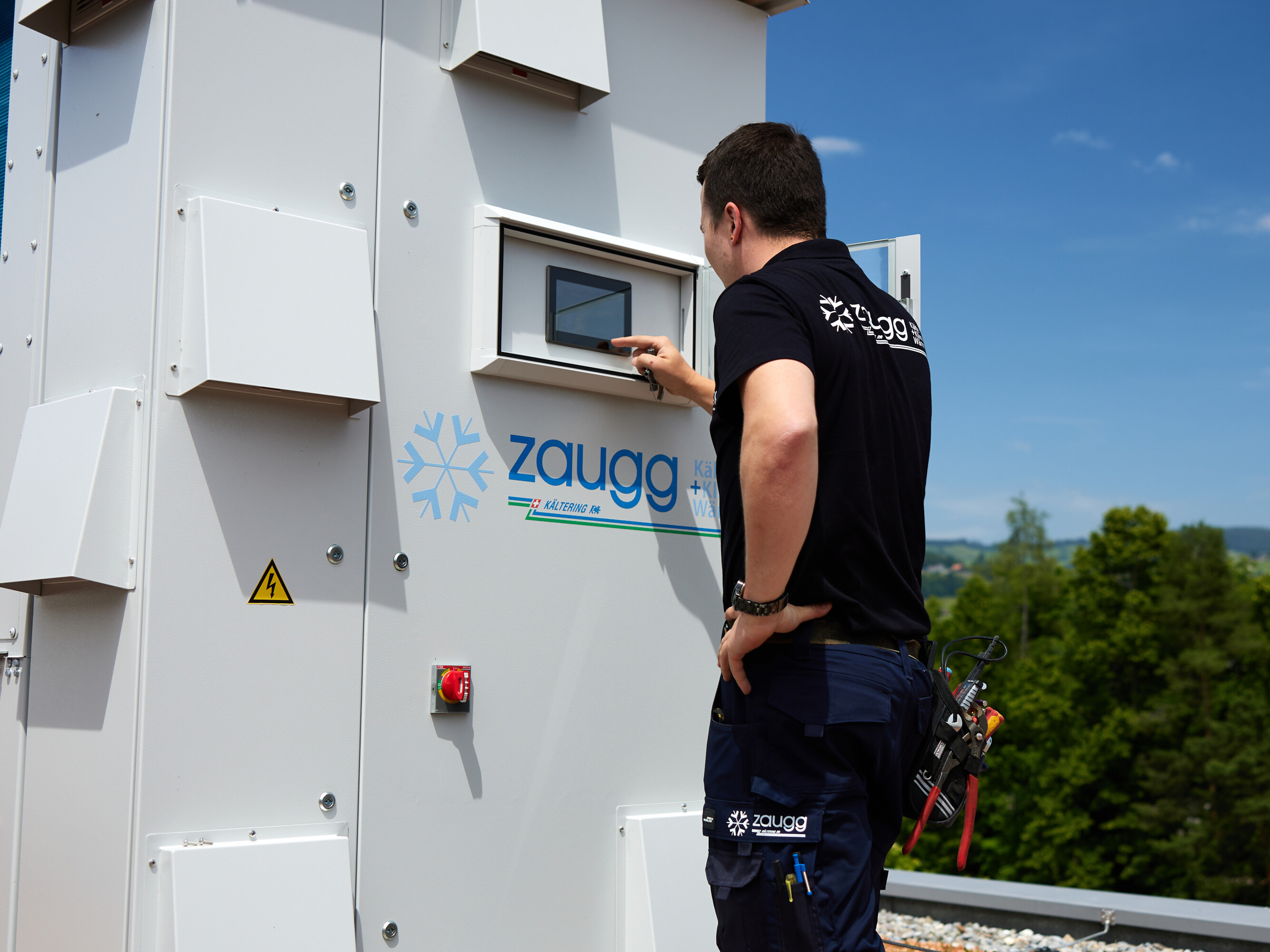 Einstellung an Display der Propan Wärmepumpe durch Kältemonteur in schwarzem T-Shirt von Zaugg AG