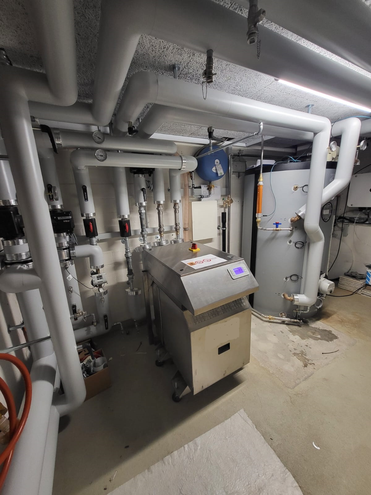 Heizungsraum mit Wärmepumpe, Speichertechnik und zentraler Regelung für die Wärmeversorgung der Mehrfamilienhäuser