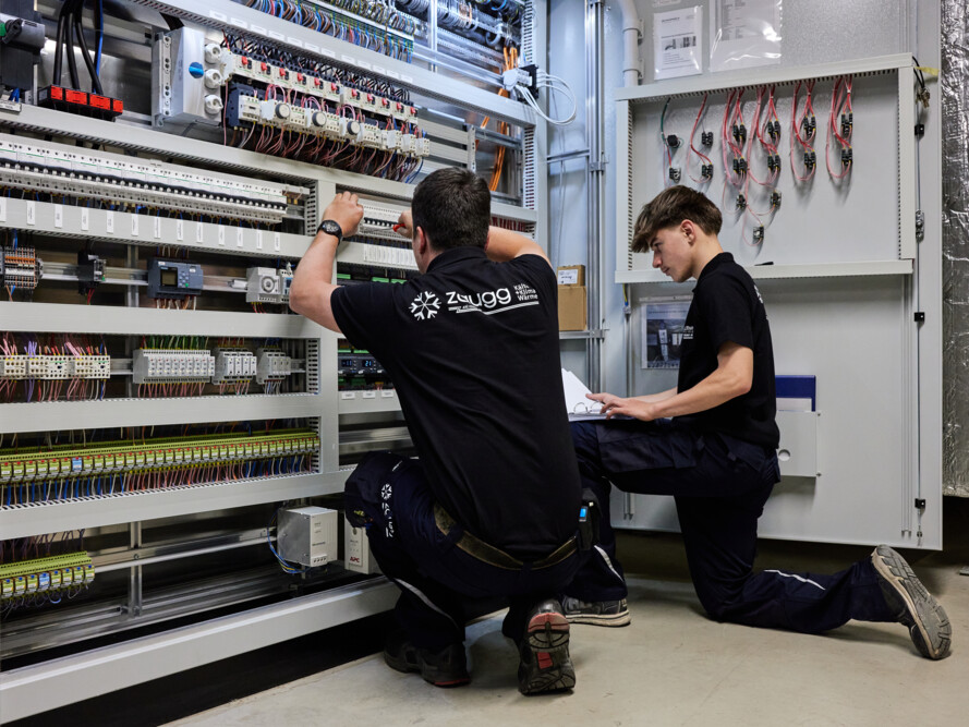 Kältesystemmonteur der Zaugg AG bei der Verkabelung einer Kälte- und Klimaanlage – Präzise Arbeit an elektrischen Steuerungen.